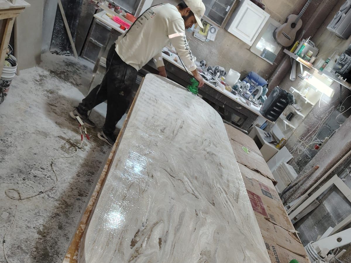 Trabajador puliendo una cubierta veteada en el taller